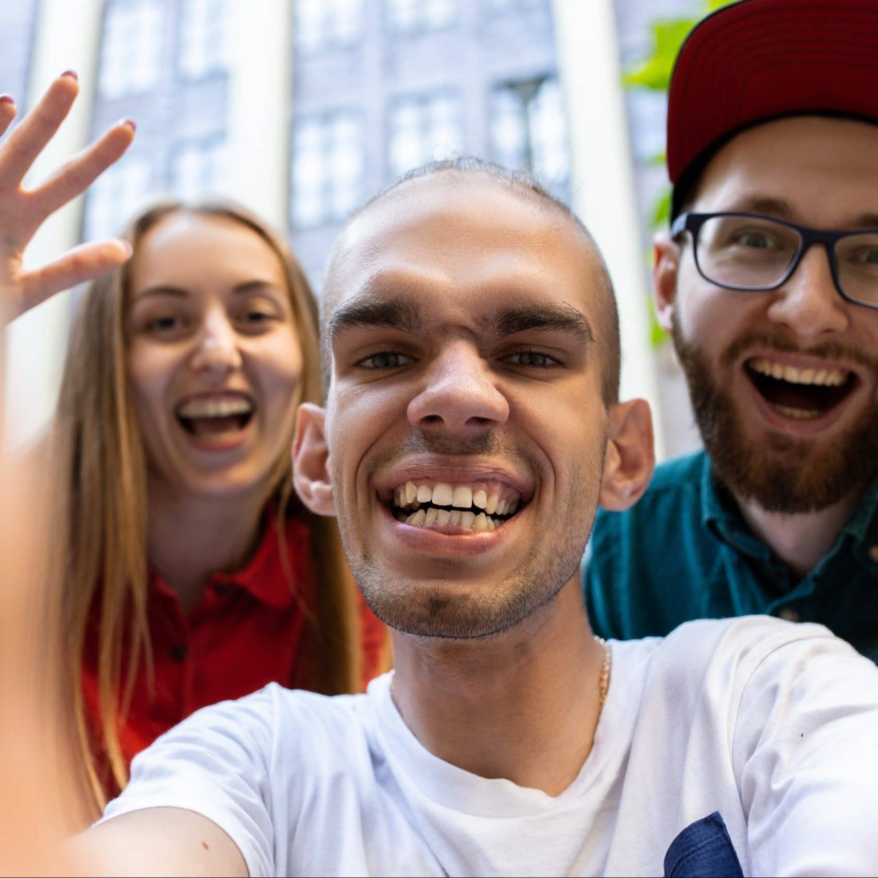 Selfie time. Group of friends taking a stroll on city's street in summer day. Man with disability with his friends or NDIS support workers having fun. Inclusion and diversity.